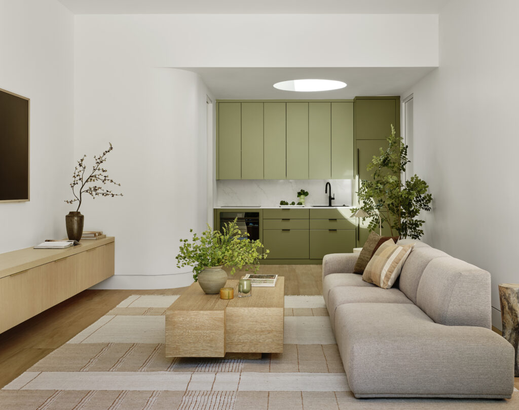 Bright, open ADU living space with oak accents, green cabinetry, and circular skylight in Lafayette, California.